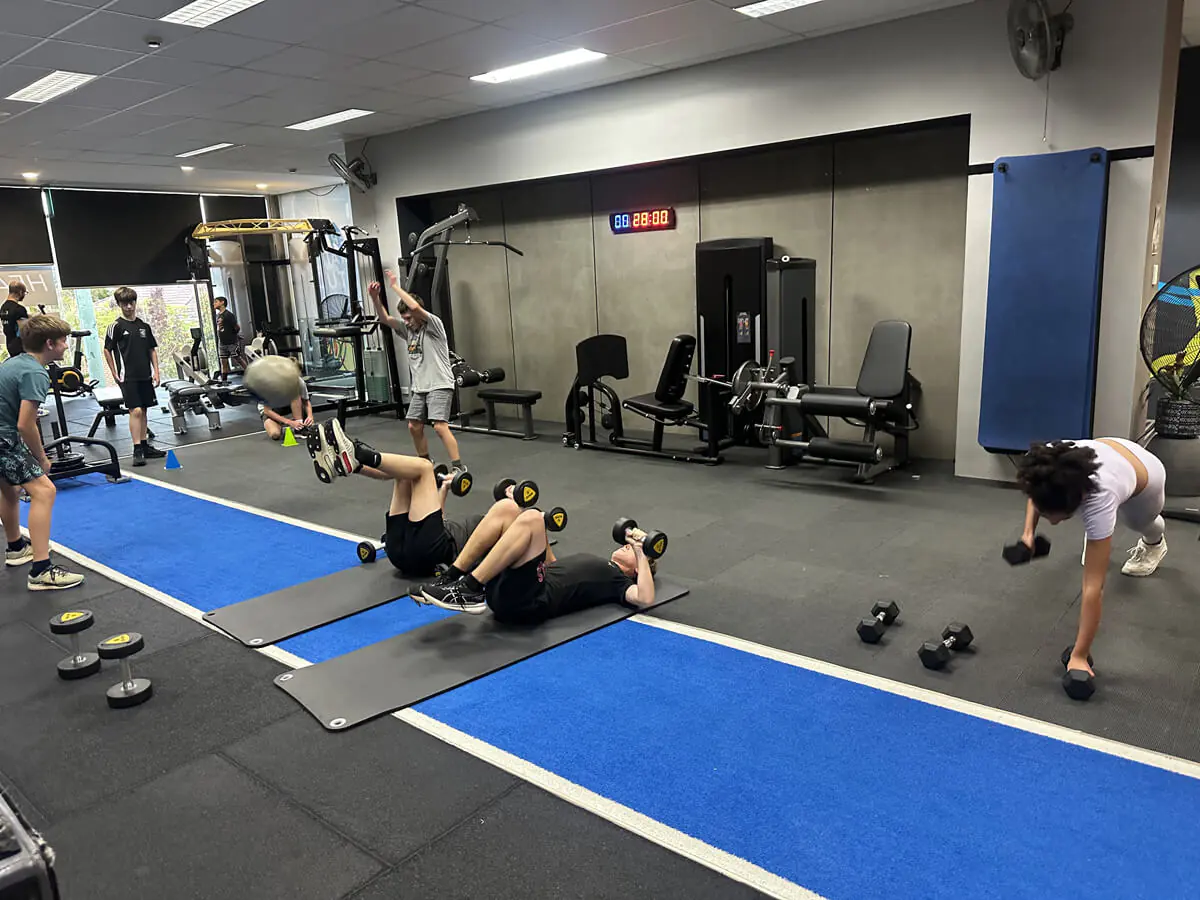 Kids training on mats with dumbbells