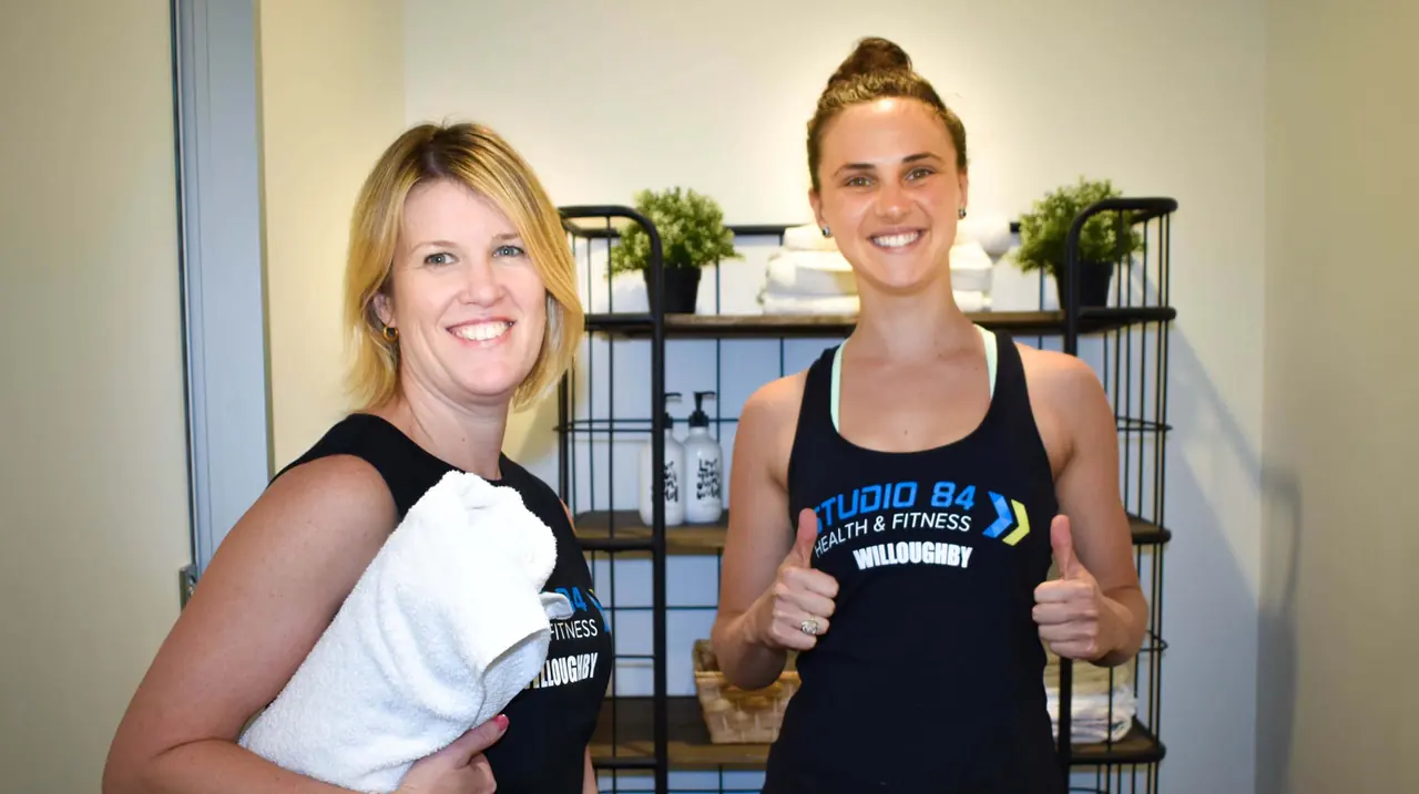 A coach and a member giving a thumbs up in the lounge